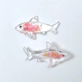 Macro shot of shark resin charms with pink dried flowers and gold flakes inside - Pink Shark