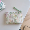 Detail of floral cotton coin purse showing woven rope zipper pull and brand tag - Light Green Leaf Pink Orange Flower