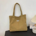 Minimalist khaki canvas tote bag with black Fashion Instinct label on black table - Dark Khaki