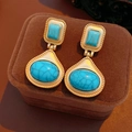 Macro shot of vintage gold earrings with turquoise stones on a brown velvet jewelry box - Gold-Light Blue