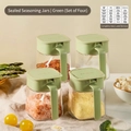 Set of 4 airtight glass spice jars with green lids and matching spoons on a kitchen table - 4-Piece Set Airtight Spice Jar | Avocado Green (1200ml Total)