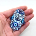 Hamsa Hand acrylic charm with evil eye and blue mandala pattern held for size comparison - Style 18