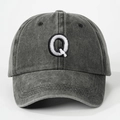Close-up of embroidered letter Q on washed charcoal grey cotton baseball cap detail - Letter Q