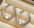 Silver twisted hoop earrings with polished metal heart charms in a beige jewelry box - Silver Style K7-94
