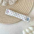 Close-up of fabric cable organizer with blue polka dots and heart button on woven mat - Blue Polka Dot