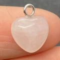 Polished pink rose quartz heart pendant charm with metal ring held on finger - 10mm / Rose Quartz