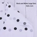 Close-up of 2cm black polka dot floral wrapping paper on a white textured wood background - White Black Big Dots