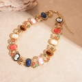 Détail d'un collier vintage doré avec pendentifs camée, gemmes résine et fleurs ciselées - Collier - Or