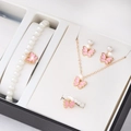 Détail d'un ensemble de bijoux papillon rose avec collier de perles et bracelet - Parure Collier Bracelet Bague et Boucles d'oreilles Papillon et Perles / Rose