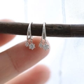 Pendientes geométricos minimalistas de plata con circonitas brillantes en una rama de madera - Oro blanco