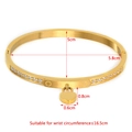 Gold-tone heart bangle in titanium steel with double rows of pavé crystals and size guide - Gold