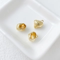 Close-up of three 14k gold-plated textured sea creature pendants in a white ceramic dish - 17# Acorn