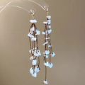 Detalle de pendientes de borla hechos a mano con conchas blancas y cordón trenzado - Estilo Fresco Blanco Concha Borla