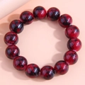 Macro shot of red and black marble texture glass beads on a minimalist beaded bracelet - Red and Black Spotted