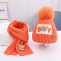 Detail von leuchtend orangefarbenem Strickset für Kinder mit süßer Bärenstickerei - Orange
