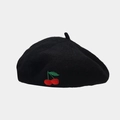 Gros plan sur un béret noir en laine avec broderie de cerises rouges et texture douce - Taille unique / Noir