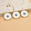 Makroaufnahme von drei goldenen Emaille-Anhängern mit blauem Auge auf strukturiertem Stein - 20.9mm / Stil 15# Sonne Runde Medaille / 1 Stück