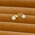 Macro shot of gold-plated curved barbell piercing with clear zircon flower pendants - Curved Ball Style (Y20370-1)