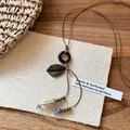 Détail du pendentif bohème en céramique avec perles en bois et feuille de bronze sur cordon - 2# Collier Marron