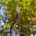 Detail of amethyst and quartz crystals in a woven macrame pouch with moon and star pendants - White Crystal + Amethyst (Silver Accessories)