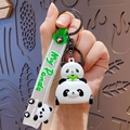 Cute cartoon panda keychain with green silicone strap and racing panda figure on hand - Panda Bumper Car