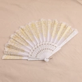 Detailed view of white plastic folding fan with gold lace patterns and golden powder - White
