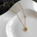 Minimalist gold heart necklace with polished pendant and small hollow accent on a tray - Gold