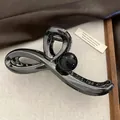 Makroaufnahme einer gun-schwarzen Haarklammer mit gedrehtem Design und großer Kugel - Gun Black - Schwarze Kugel