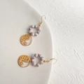 Dettaglio di orecchini boho in oro con perle di marmo bianco e motivi celestiali - 122 Sole luna / Bianco