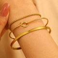 Close-up of gold 3-piece bracelet set with box chain and knotted bangle on wrist - Box Chain Knot Combination (3081)