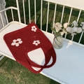 Detail der roten Stricktasche mit weißen Blumenmustern auf einer weißen Bank - Rot