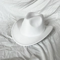 Detailed close-up of white felt fedora hat featuring decorative brim stitching and top crown contour - White