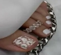 Close-up of silver toe ring with textured design and leopard print nail art stickers - FW12