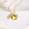 Elegant gold heart locket necklace with sparkling white crystals on a white ceramic plate - Gold