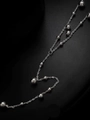 Macro di una collana a nappe d'argento con dettagli di sfere metalliche lucide - Collana / Color Acciaio