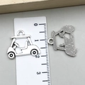 Detailed size measurement of vintage silver golf cart and golfer pendants using a ruler - Golf Cart