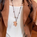 Detail view of a brown leather pony pendant necklace on a model with blue woven cord - 21# Necklace Coffee Brown Leather Style