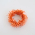 Detailed view of an orange textured PVC wreath candle ring with festive pine needle fibers - 6cm Orange Tinsel Ring