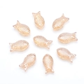 Macro detail of nine translucent amber fish-shaped glass beads in a circular arrangement - Amber Gold