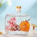 Preserved pink flower and dried orange slice in glass diffuser bottle with gold cap - Shangri-La