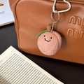 Handmade pink wool felt peach keychain with smile embroidery on a stylish bag - Happy Peach