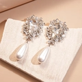 Dettaglio macro di orecchini a goccia con metallo argentato e perle bianche finte - Argento (Perno in argento)