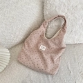 Gros plan détaillé d'un sac cabas en velours côtelé rose avec motif floral et logo - Rose