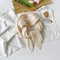 Elegant beige pleated silk scarf folded on a white tray with tulip decor and natural soft light - 70*70cm / Pleated Jade