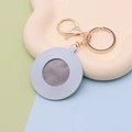 Detail of light blue faux leather keychain mirror with gold metal ring and clear reflection - Round Light Blue
