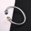 Detail of silver twisted cable bracelet featuring blue stones and gold accent rings - Blue Gemstone / Silver Cable