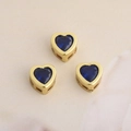Trois breloques cœur dorées avec zircon bleu sur tissu clair pour création de bijoux - Bleu