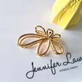 Close-up of golden metal butterfly hair claw clip on a white minimalist platform - Flower Hollow Claw Clip / Gold
