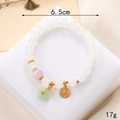 Détails macro d'un bracelet en perles avec pendentifs muguet et breloque porte-bonheur - Style Disque Rond Fu Blanc