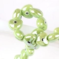 Macro shot of green heart-shaped ceramic evil eye beads for handmade jewelry making - 13x14mm / Green